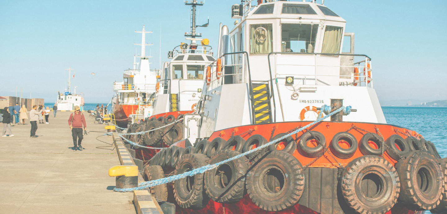 Imaxe dun porto pesqueiro. Na marxe dereita da imaxe atópanse varios barcos atracados.
