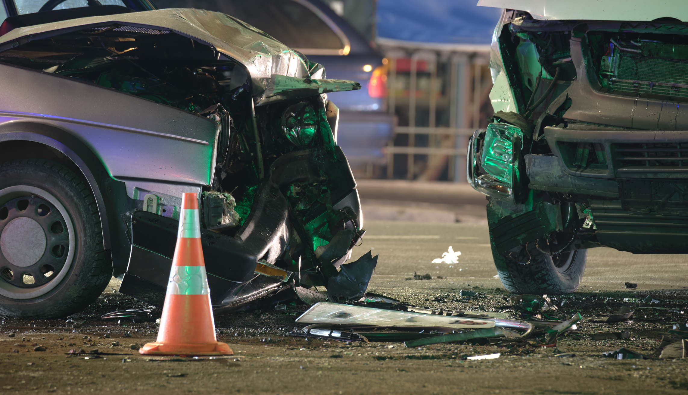 A imaxe está a mostrar un accidente de tráfico e están a dúas partes delanteiras dos vehículos esnaquizadas.